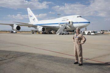 a woman standing in front of a plane