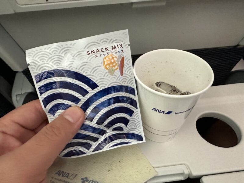 a hand holding a packet and a cup of coffee