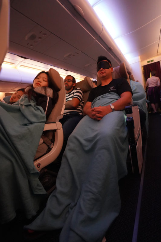 a group of people sleeping in an airplane