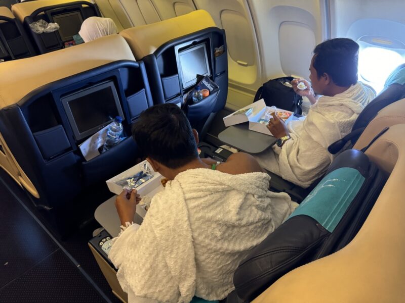 a group of people sitting in a plane eating