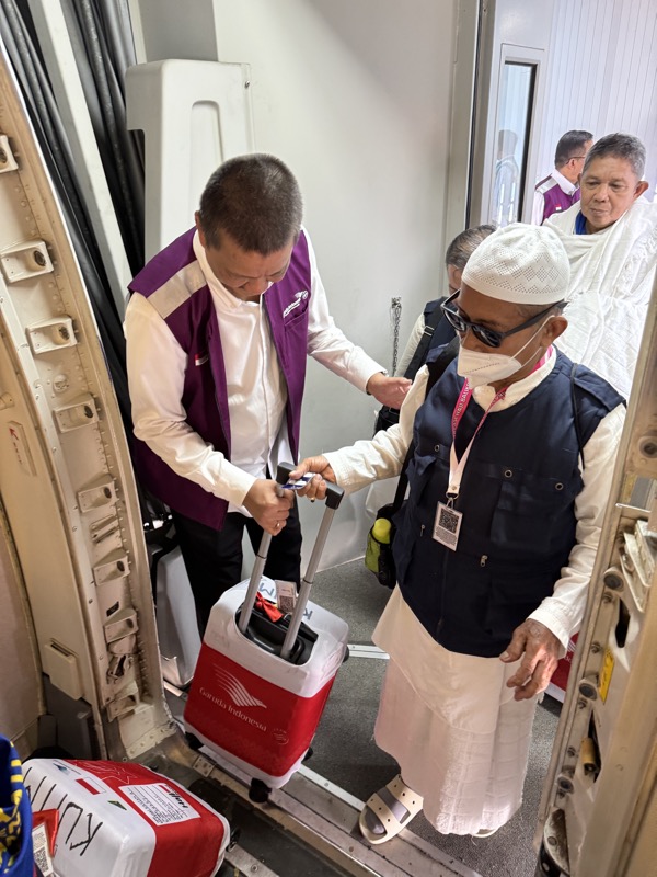 a man in a white robe and a white hat with a red cooler and a red cooler with a white and red cooler with a red handle