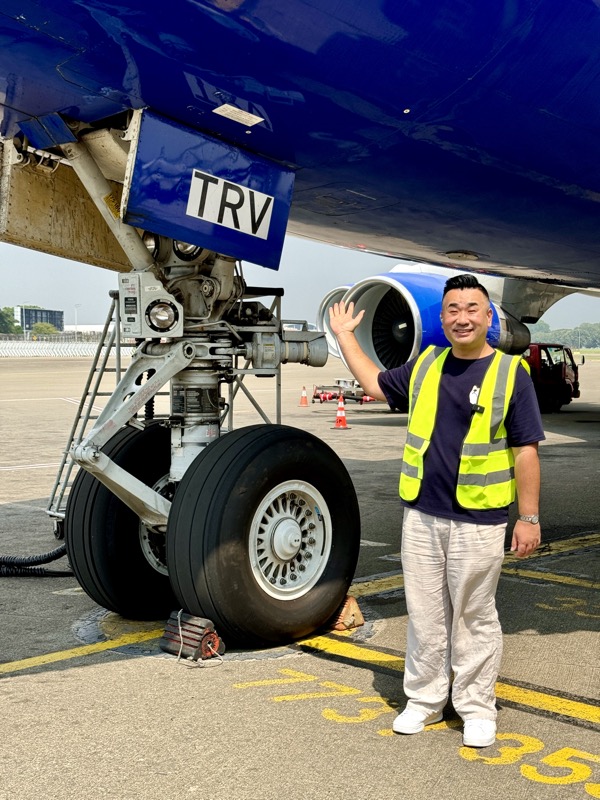 a man waving in front of a plane
