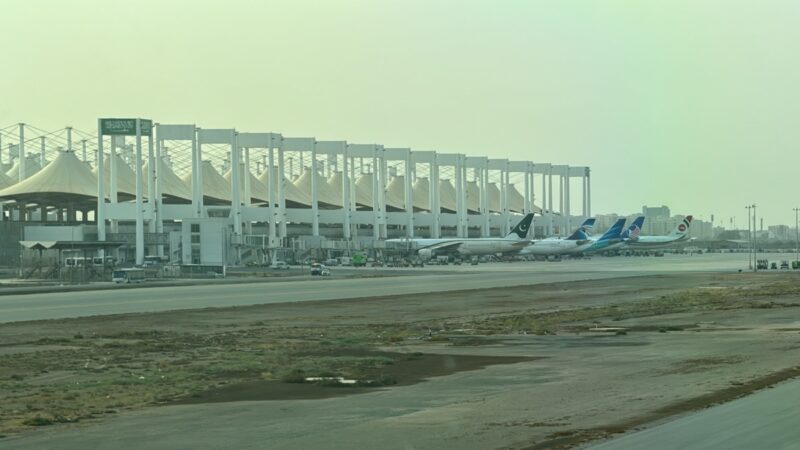 a group of airplanes parked in front of a large white building