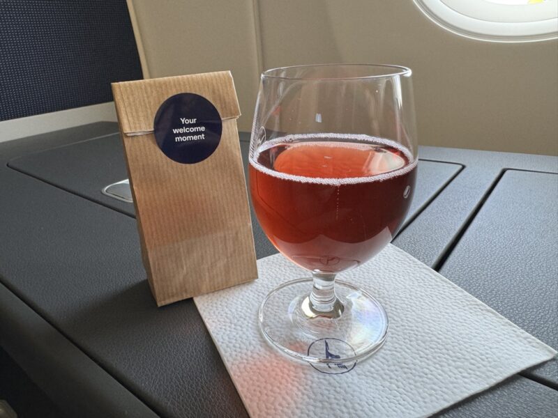 a glass of liquid on a napkin next to a brown bag