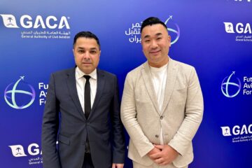 two men standing in front of a blue wall