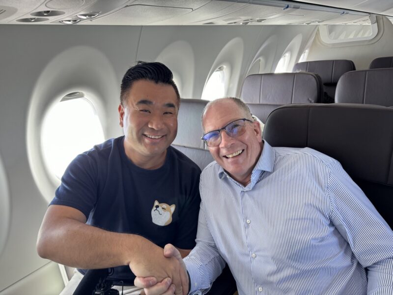 two men sitting in an airplane