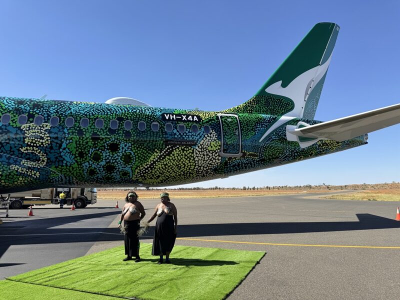 two people standing next to a plane