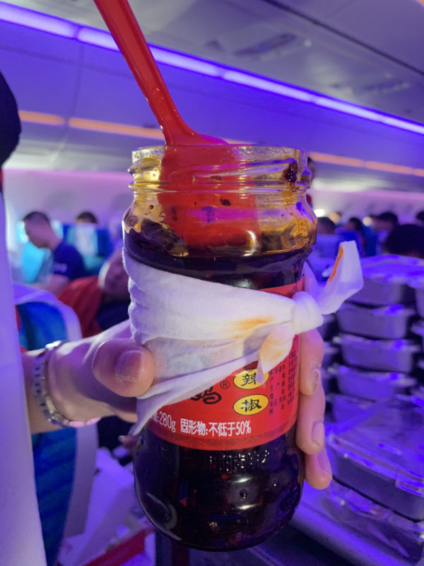 a hand holding a jar of liquid