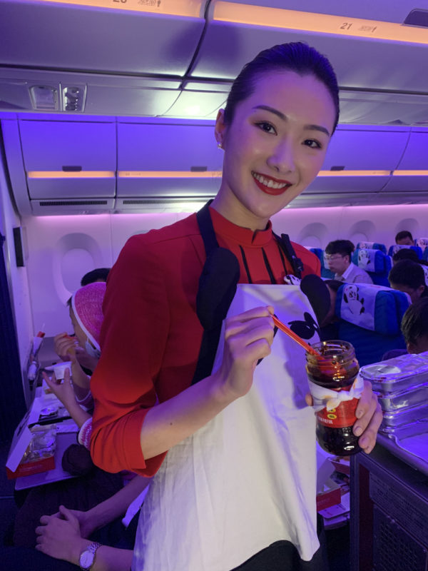 a woman in an apron holding a jar of jelly