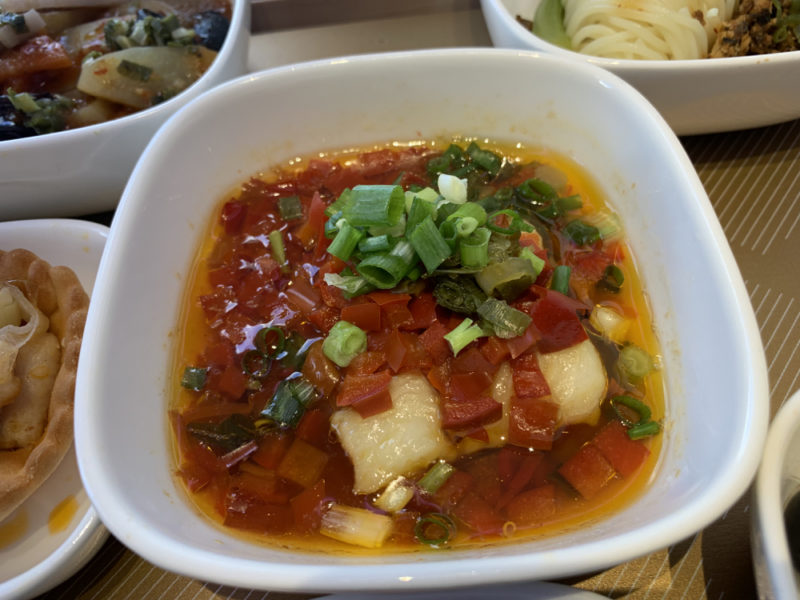a bowl of soup with vegetables and greens