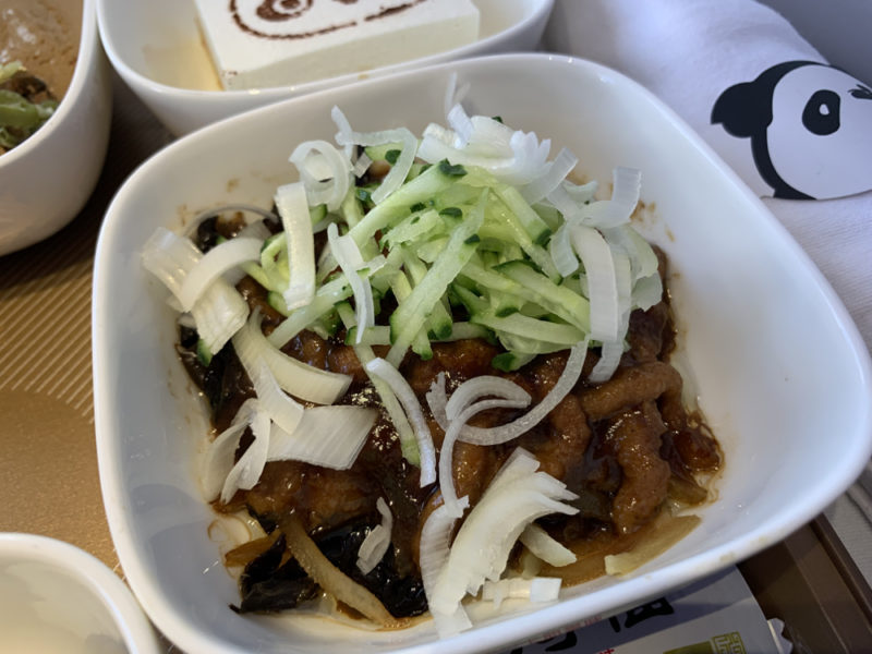 a bowl of food with onions and meat