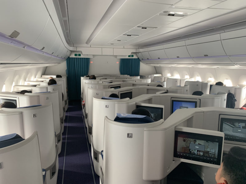 a plane with rows of seats and monitors