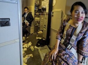 a woman sitting in a room with a man sitting on the floor