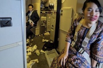 a woman sitting in a room with a man sitting on the floor