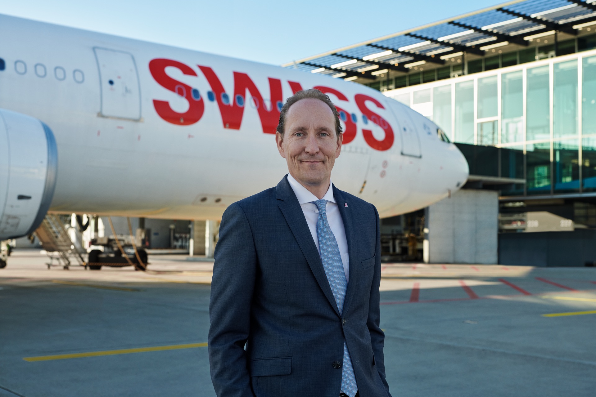 a man in a suit standing in front of a plane
