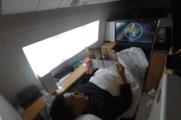 a man lying in bed reading a book