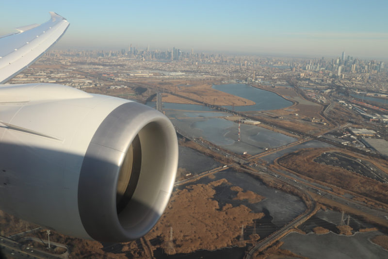 an airplane wing with a city in the background